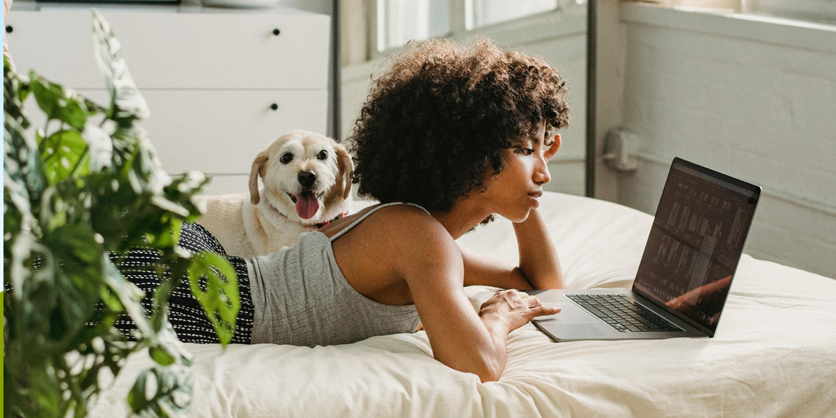Woman researching flame retardants on her laptop while her dog sits close by