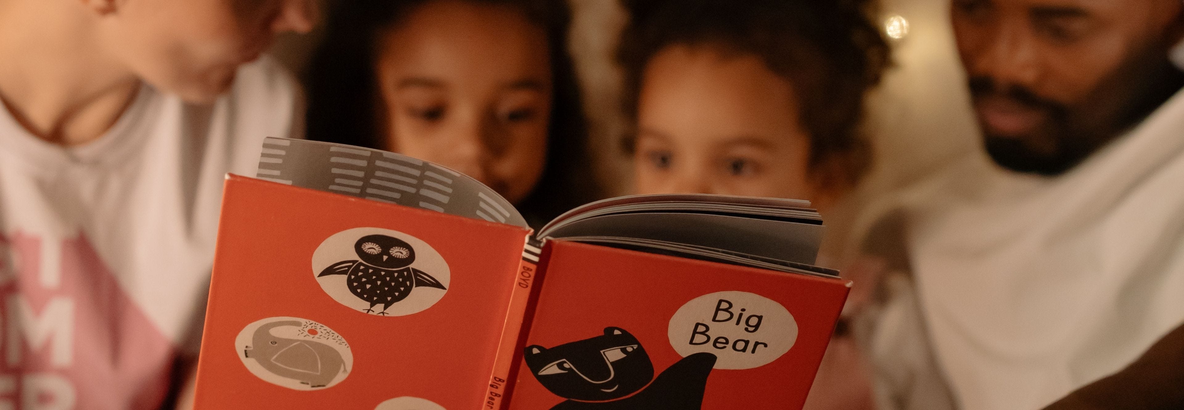 family reading bedtime stories to children