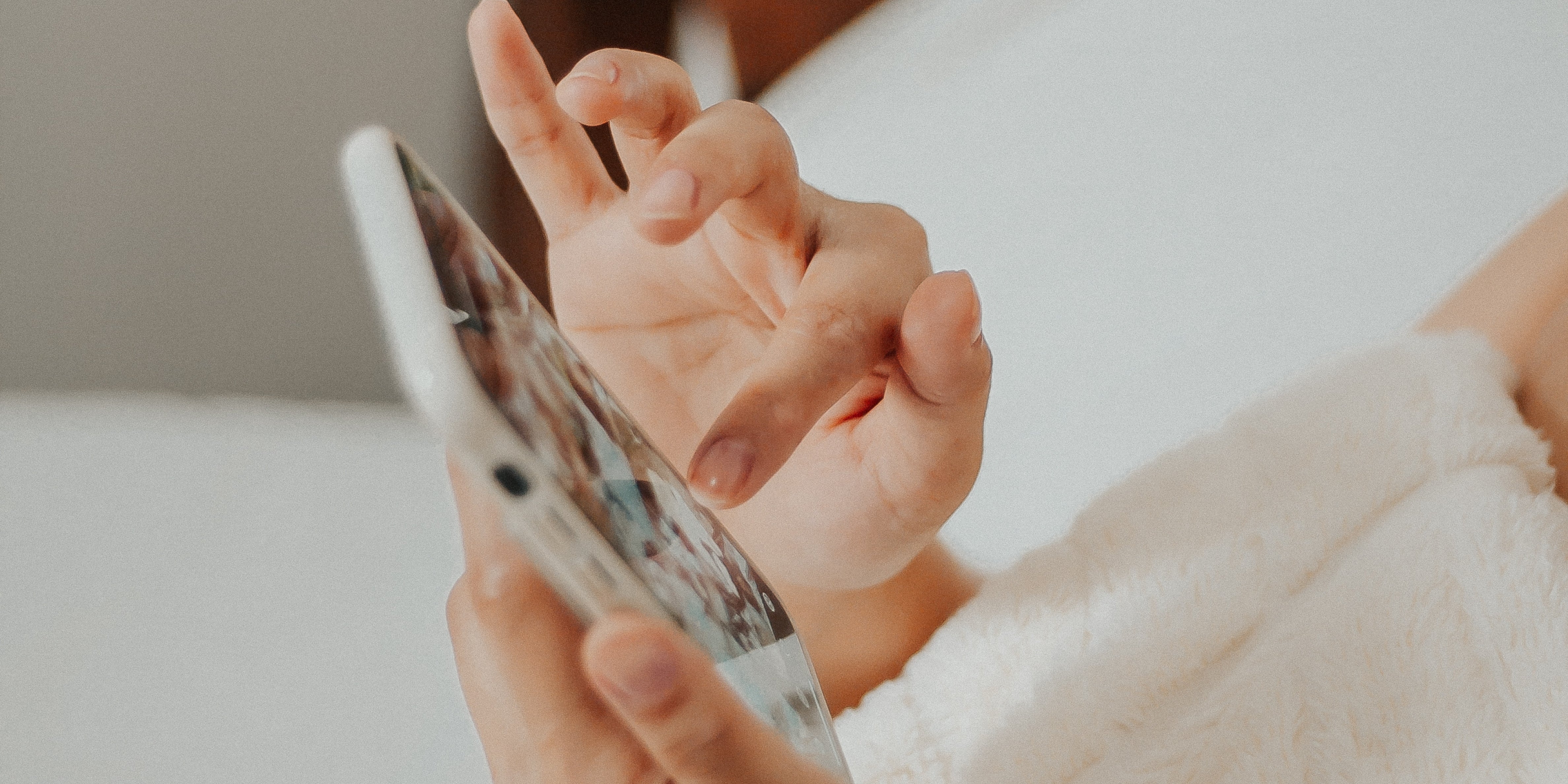 Woman using phone in bed