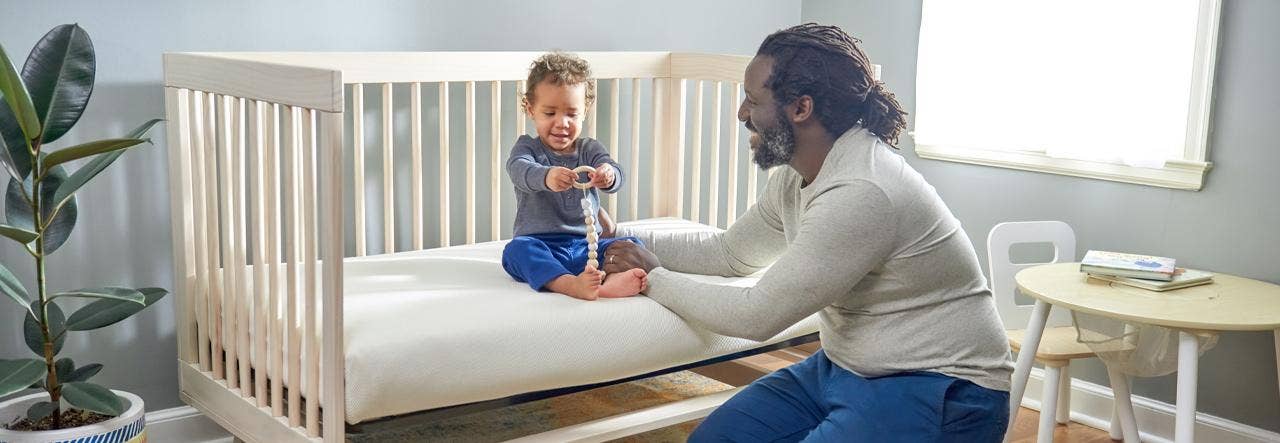 Dad and son on NP crib mattress playing