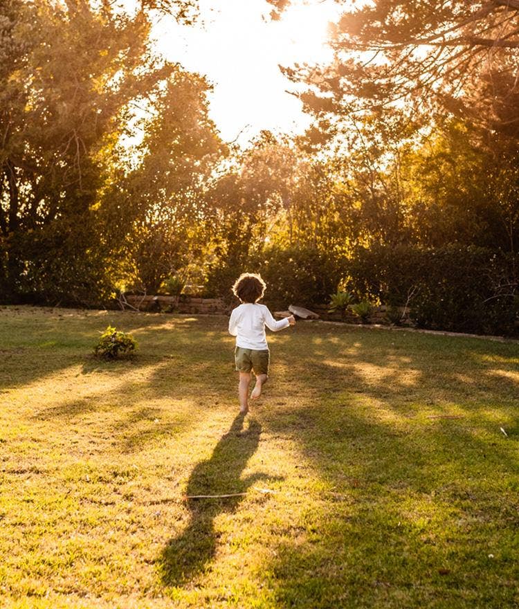 Child running barefoot in the grass 