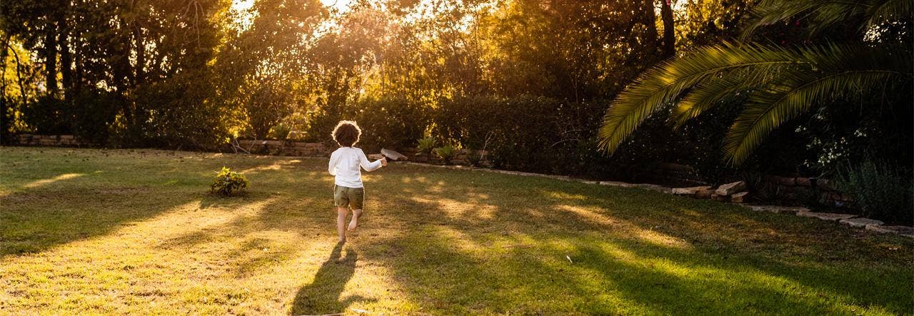 Child running barefoot in the grass 