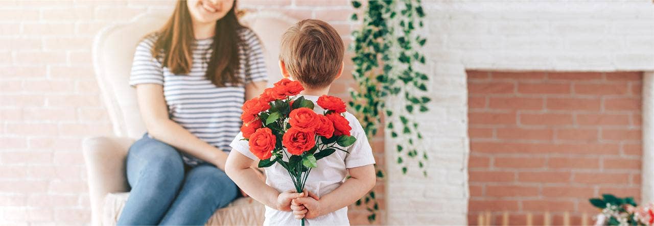 boy bringing mother bouquet of flowers