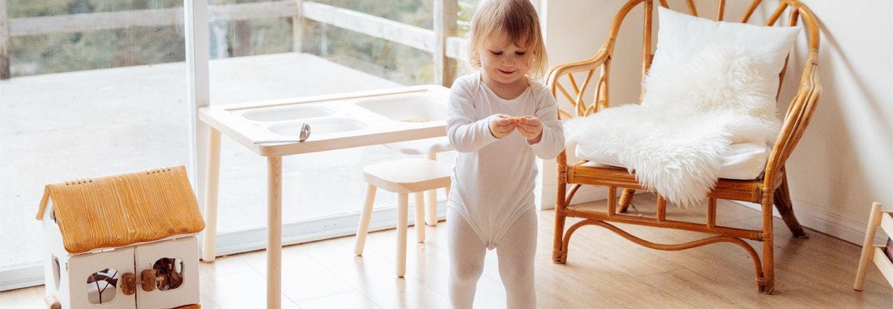 Toddler standing in a clean, naturally lit living room