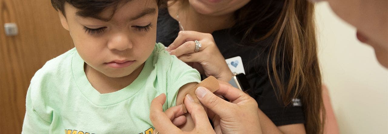 Little boy getting his bandaid after receiving the flu shot