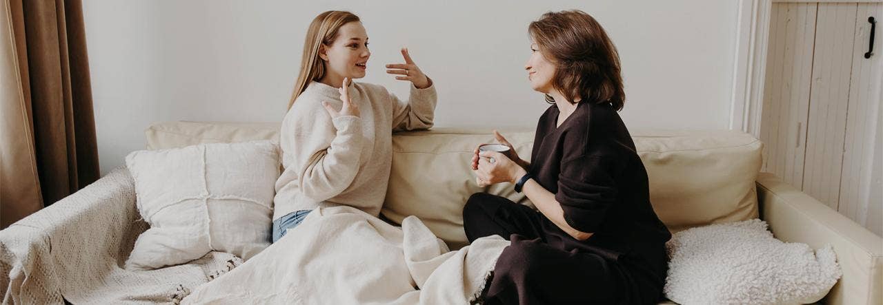 Mother and teen daughter talking on the couch at bedtime