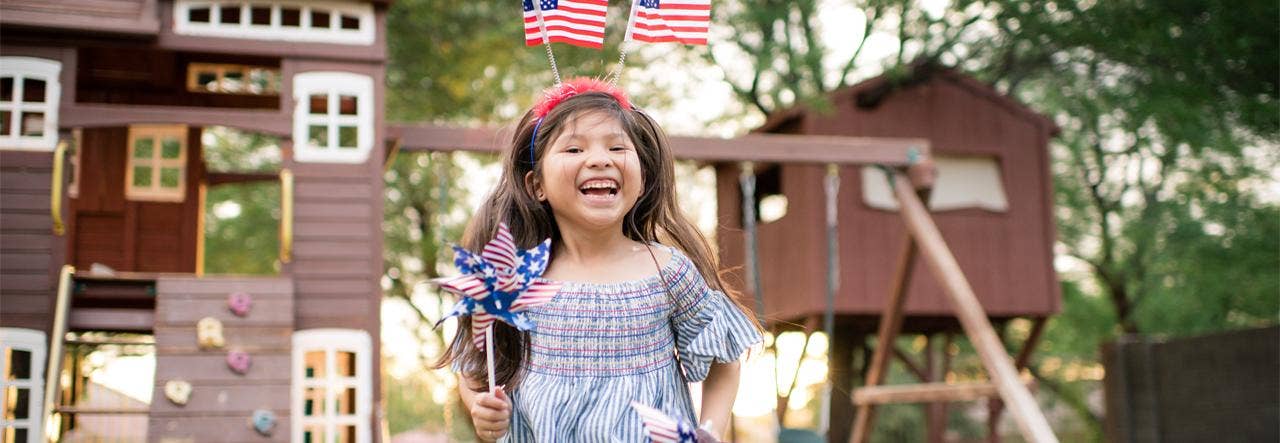Young girl celebrating July 4th outdoors with patriotic decorations