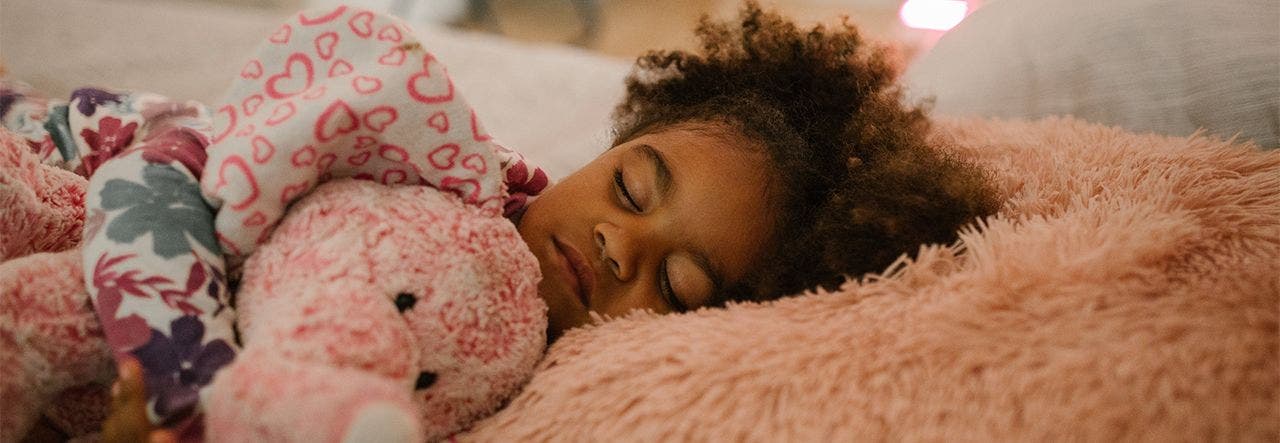 Young girl sleeping soundly with her stuffed elephant