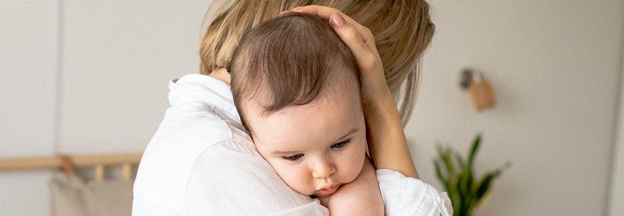 Mother holding baby and cradling their head