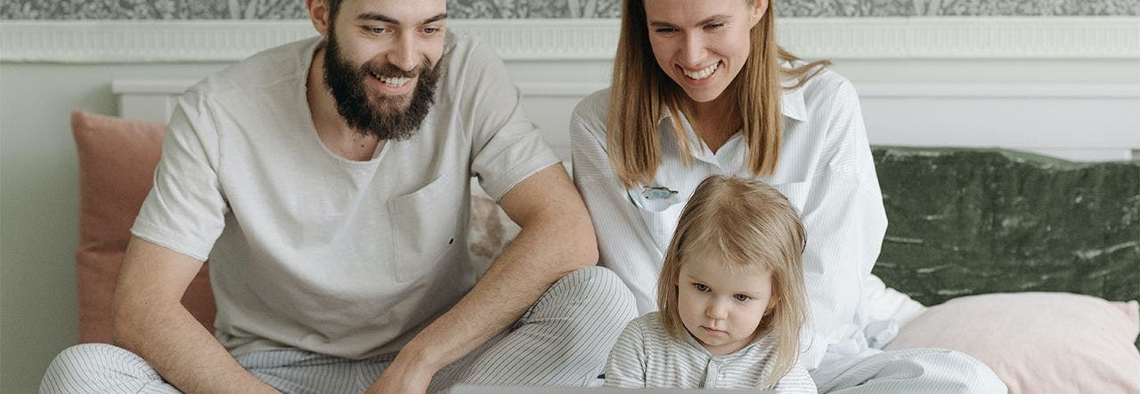 Family relaxing on the bed together in a safer, healthier home