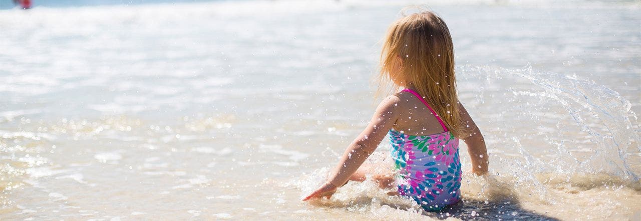 Toddler girl playing in the surf on the beach