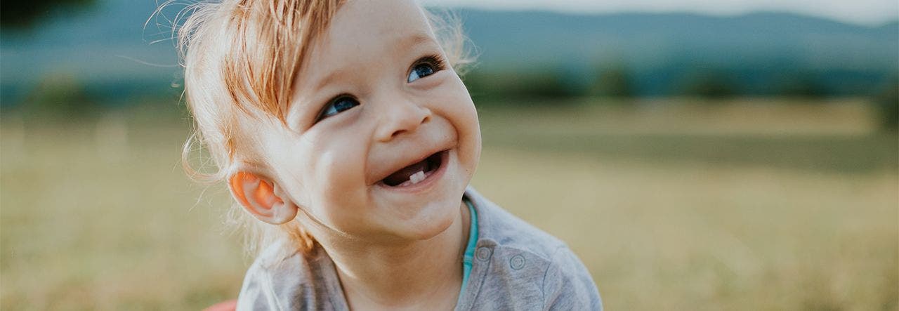 Smiling toddler with two bottom teeth