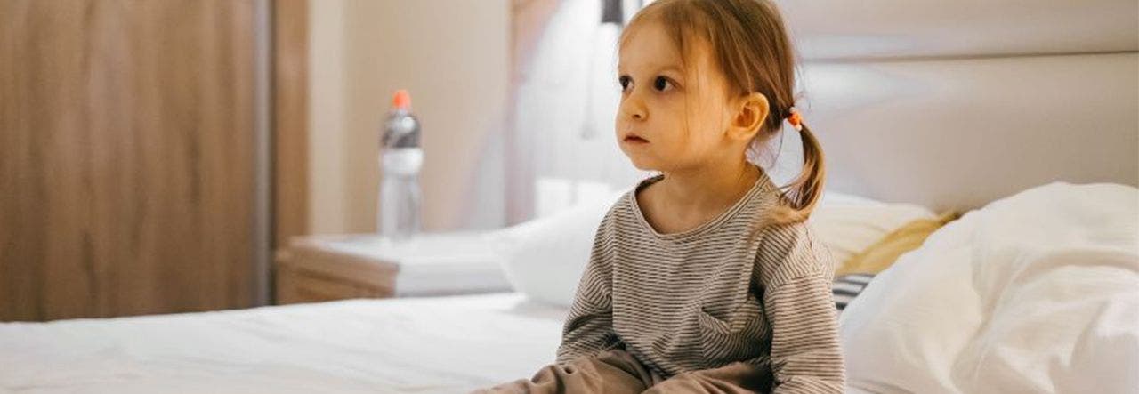 Toddler sitting up wide awake in bed