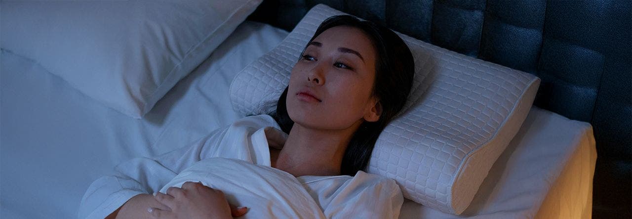 Exhausted man sitting up in bed