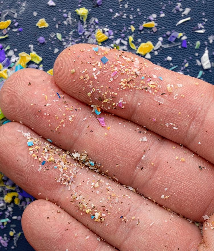 hand holding multicolored microplastics