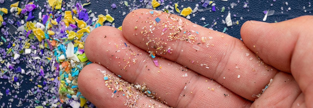 hand holding multicolored microplastics