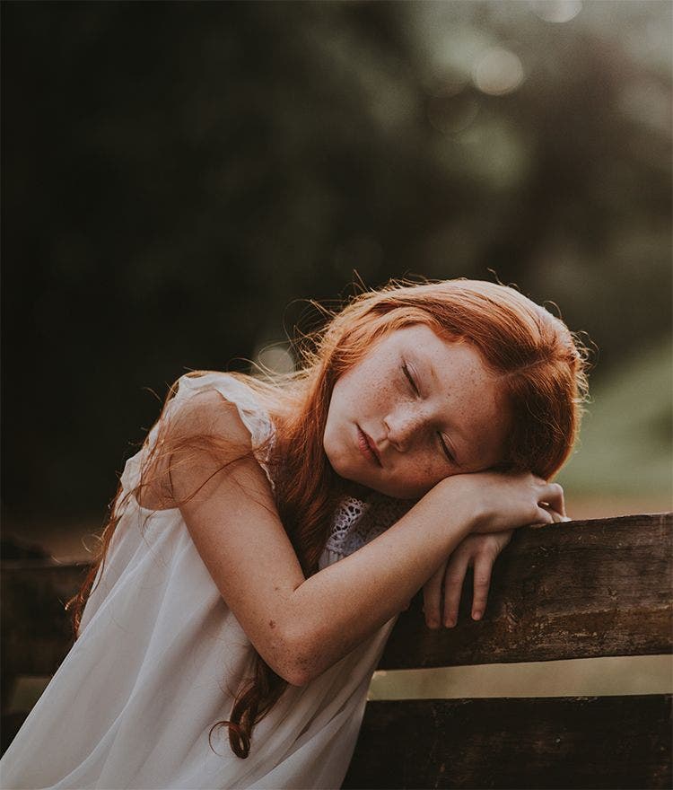 School-aged girl sleeping outside