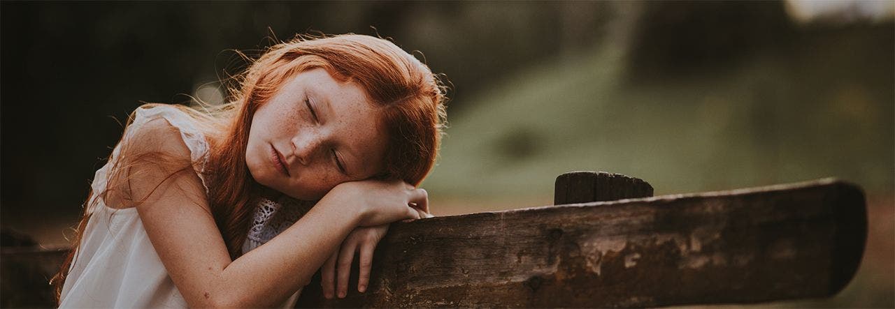 School-aged girl sleeping outside