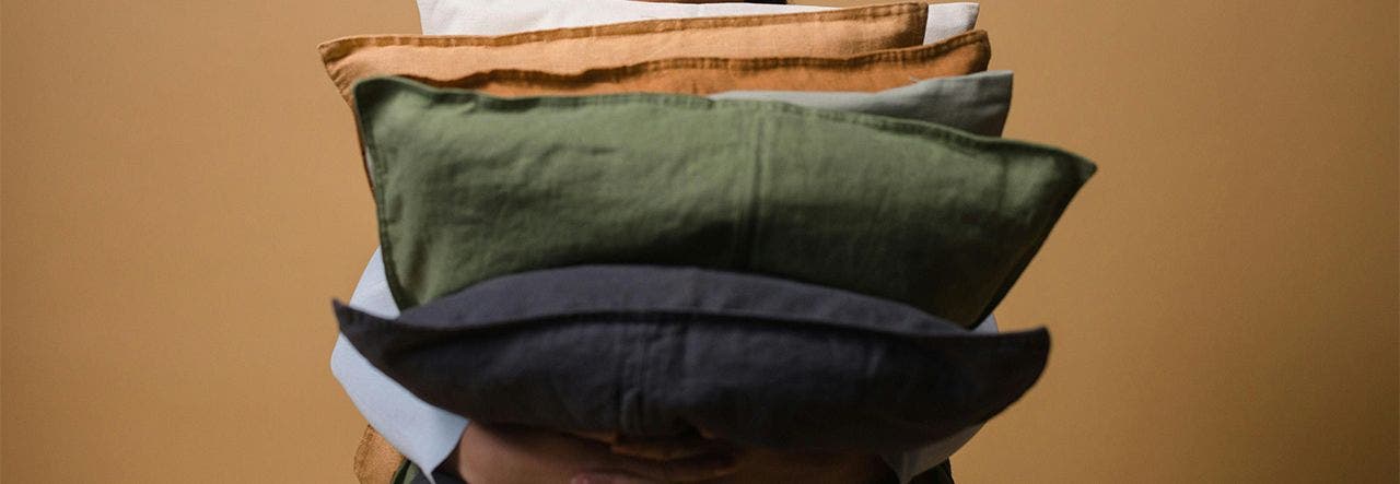 Woman fluffing an old pillow
