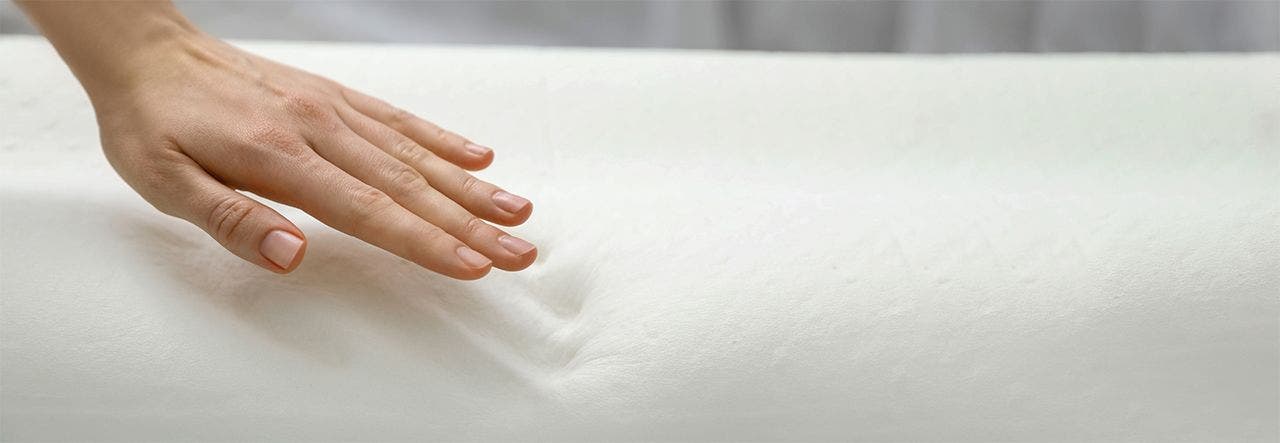 Woman's hand leaving an imprint on a soybean foam mattress