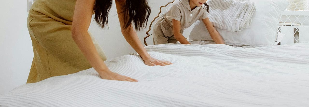 woman smoothing out the surface of a mattress