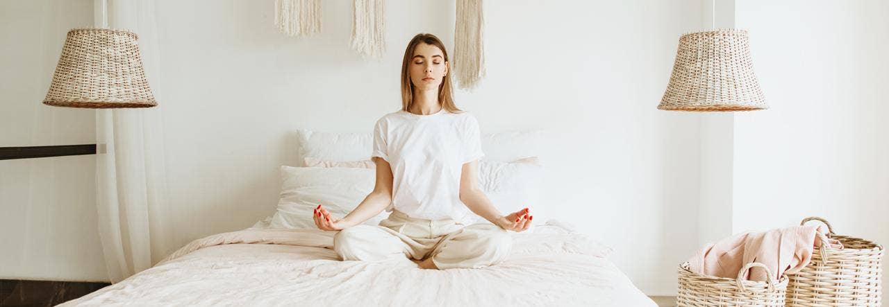 woman meditating on bed