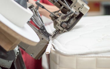 Close-up of mattress being sewn closed