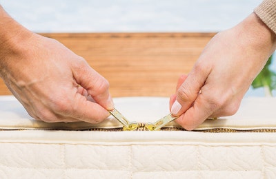 Couple holding zipper pulls after assembling EOS mattress