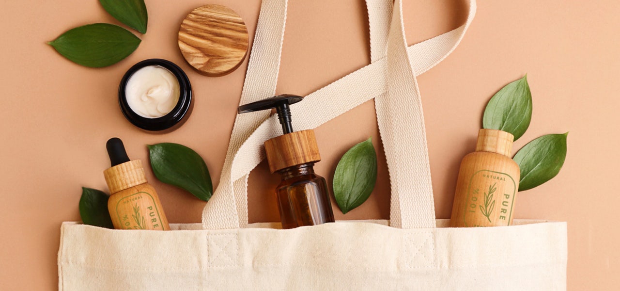 Natural-looking cosmetic products displayed spilling out of a canvas bag 