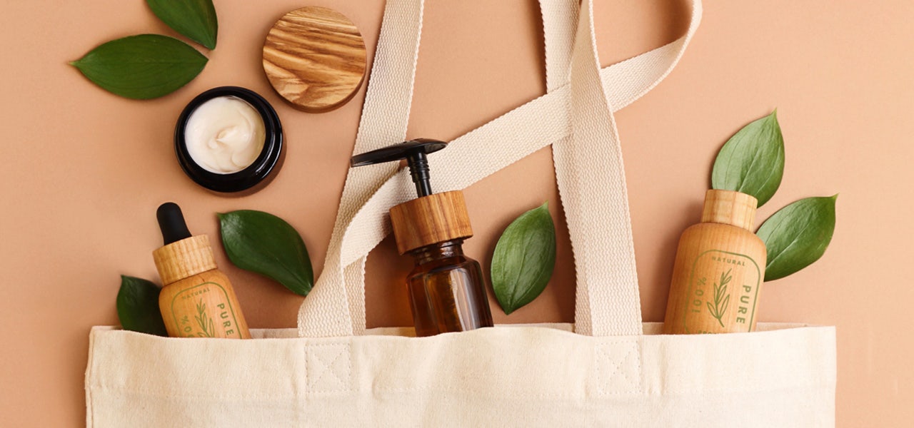 Natural-looking cosmetic products displayed spilling out of a canvas bag