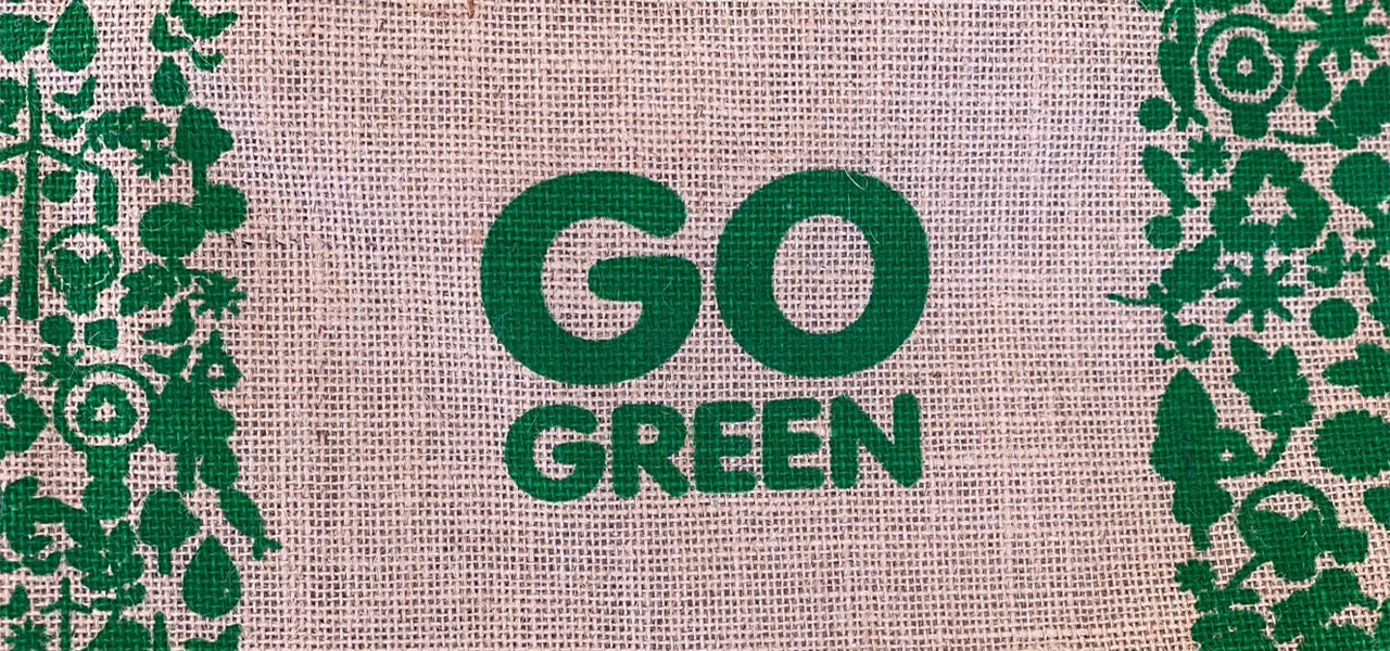 The words "Go Green" stamped on burlap with recycling and nature illustrations