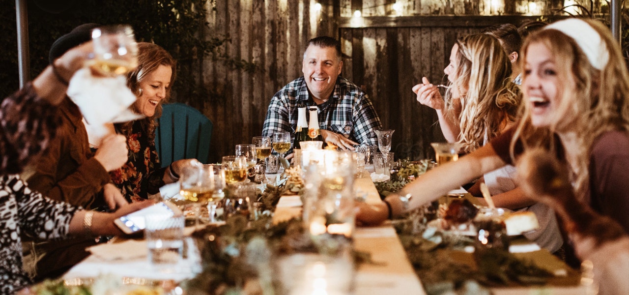 Family laughing and sharing a holiday meal around the table 