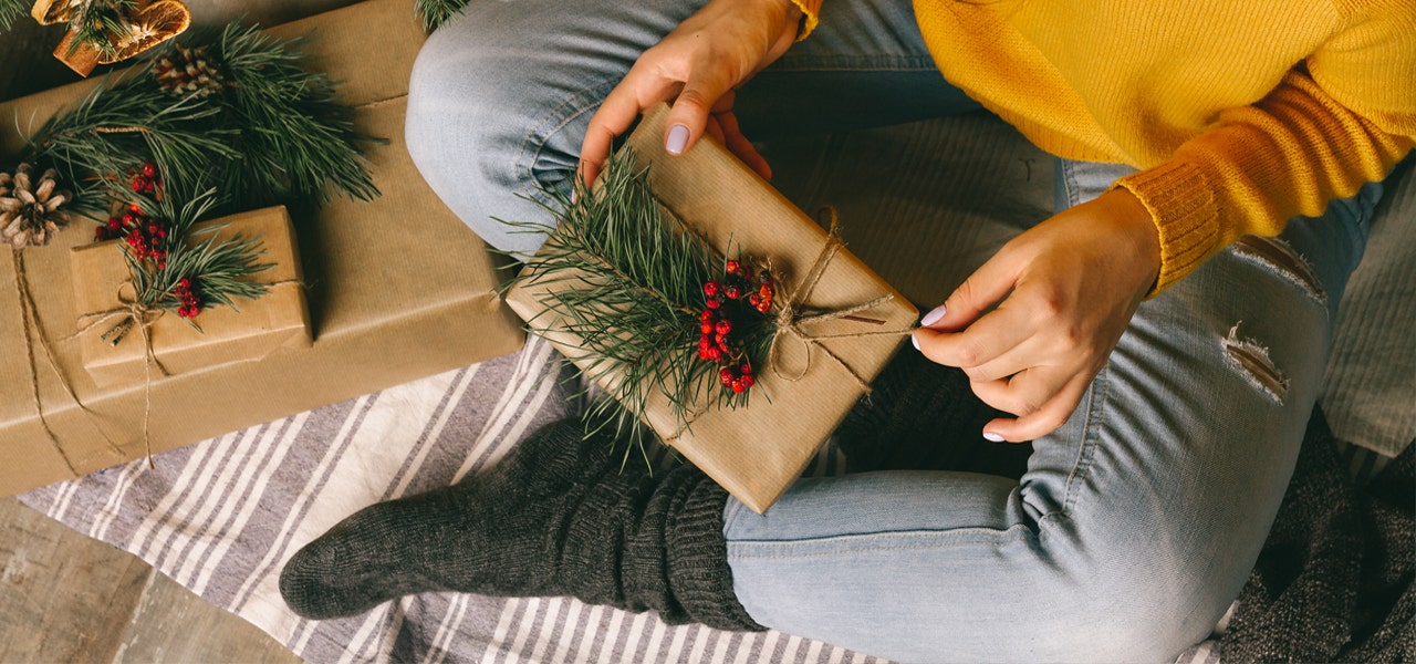 Overhead view of a woman with a neatly wrapped gift in her lap