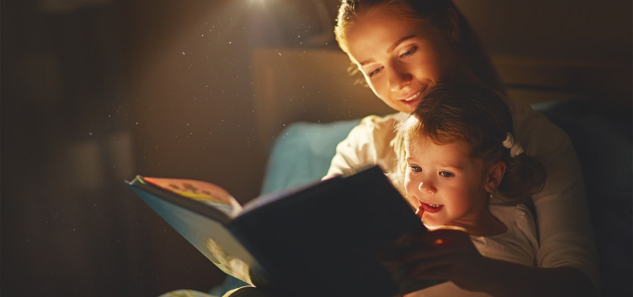 Mother and toddler looking at a book together