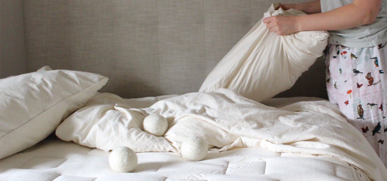 Woman removing an organic pillow from its pillowcase