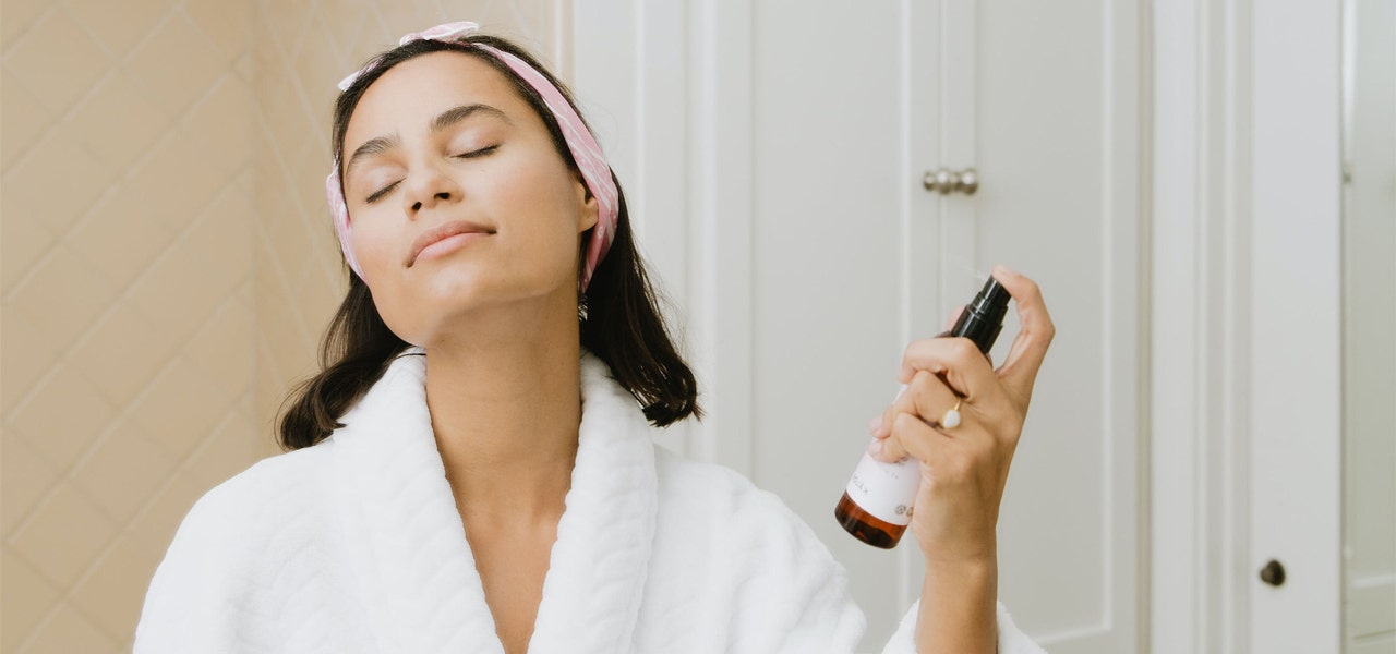 Woman in a robe completing her bedtime skincare routine