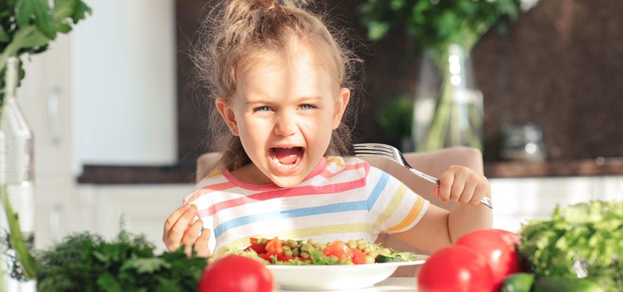 Young girl eating a salad outside 