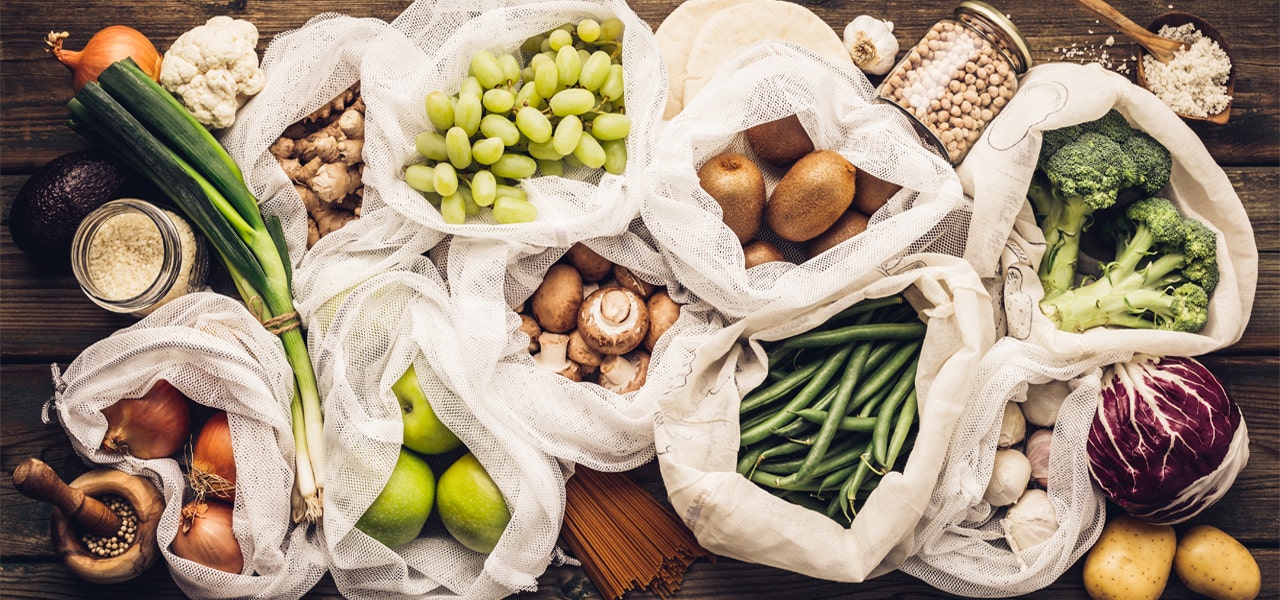 Reusable shopping bags full of fresh produce 