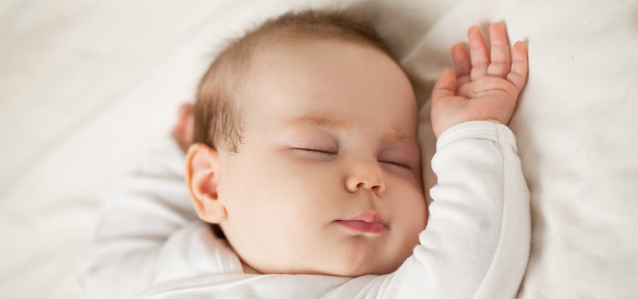 Baby sleeping on their back on a non-toxic crib mattress