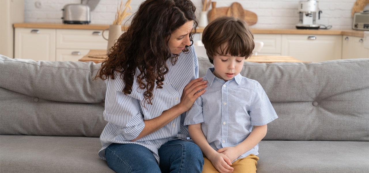 Mother and young child sitting on the couch discussing a bad dream