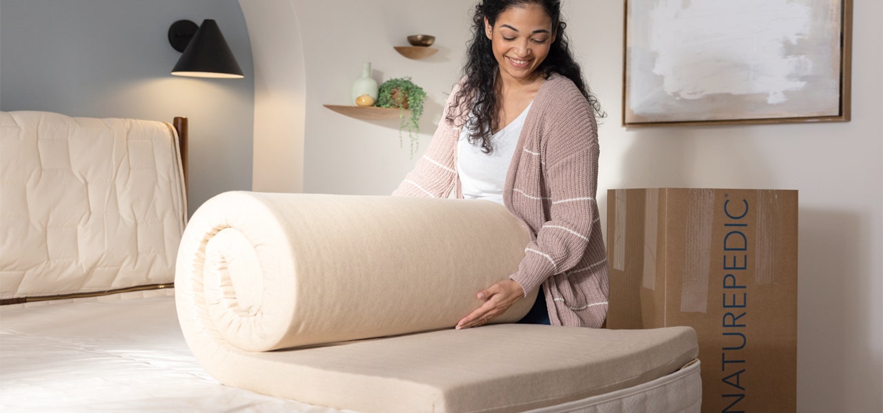 Woman unrolling thr latex layer of her EOS organic mattress