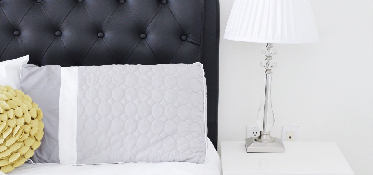 Pillow propped against a vinyl leather headboard 