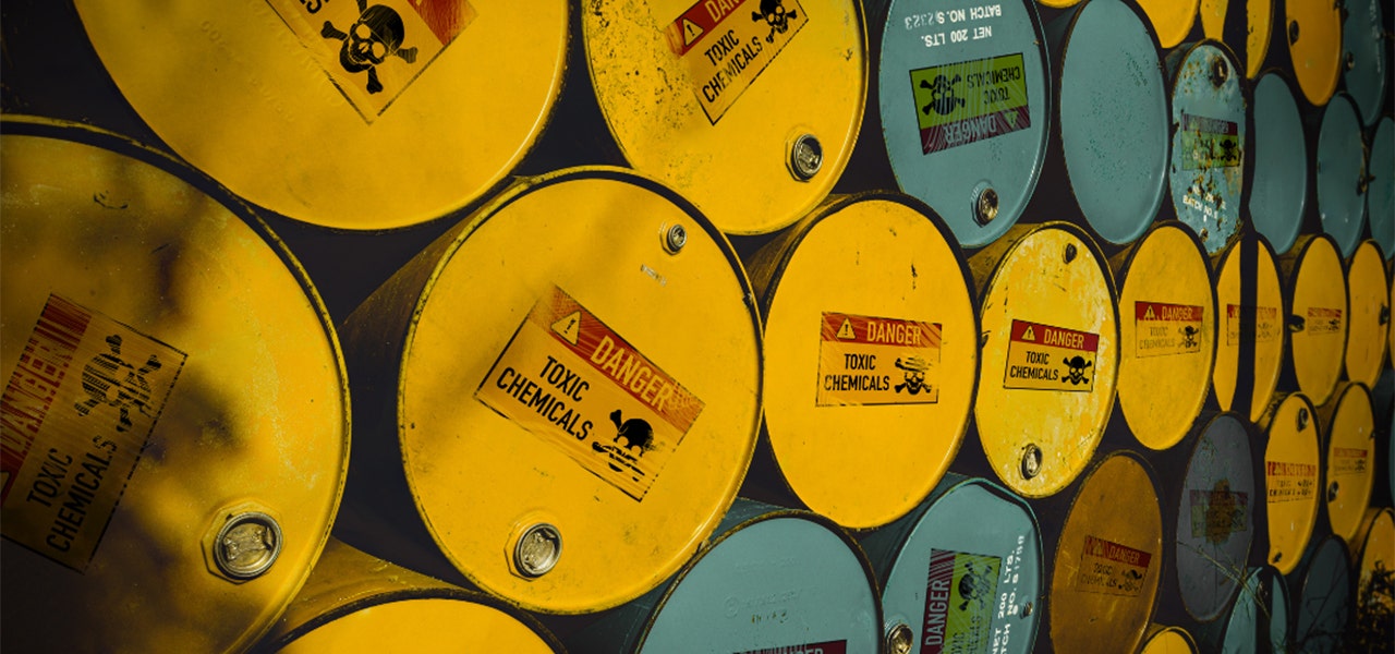 Brightly colored metal barrels with signs reading "Danger" and "Toxic Chemicals"