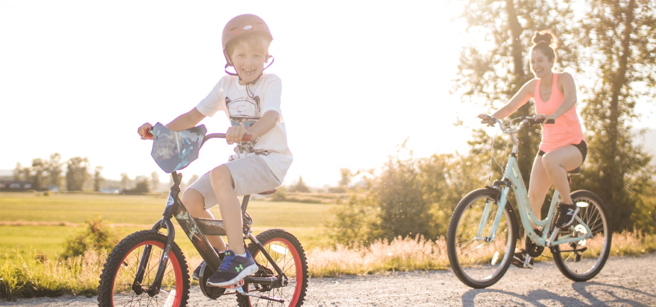 Mother and son riding bikes outside in the sunshine 