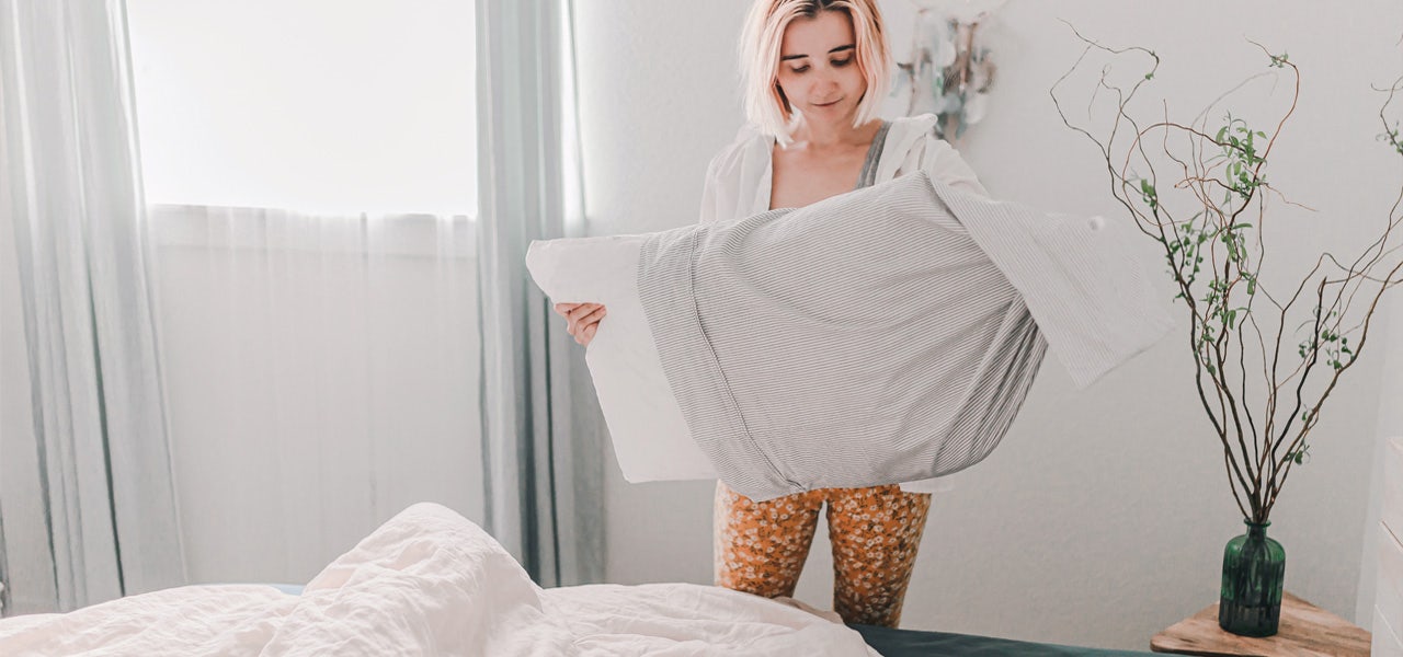 Woman removing her pillow from its pillowcase to wash it