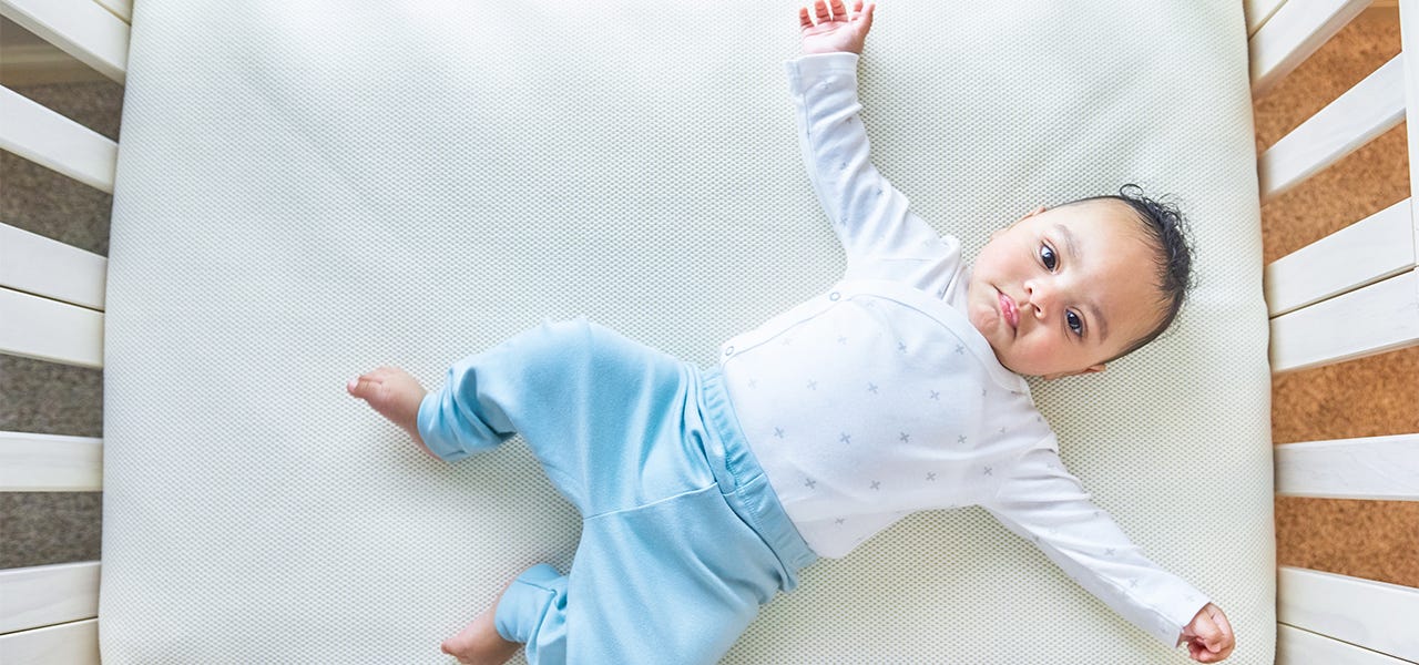 Baby lying awake on a Naturepedic organic mattress