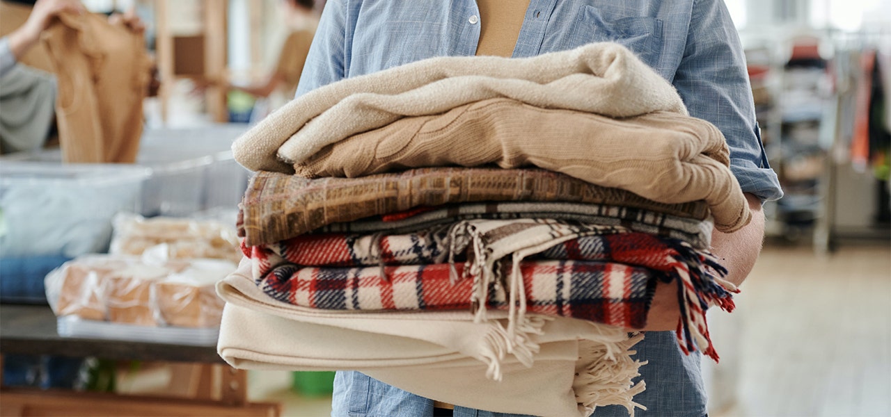 Local business employee carrying a stack of folded organic knitware