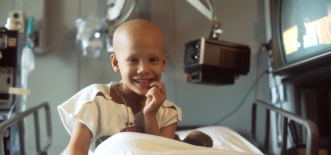 Child in a hospital bed during cancer treatment