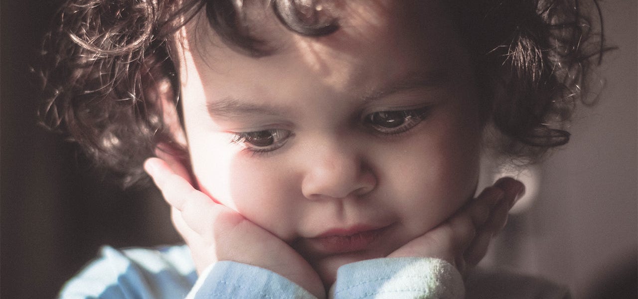 Toddler resting their chin in their hands