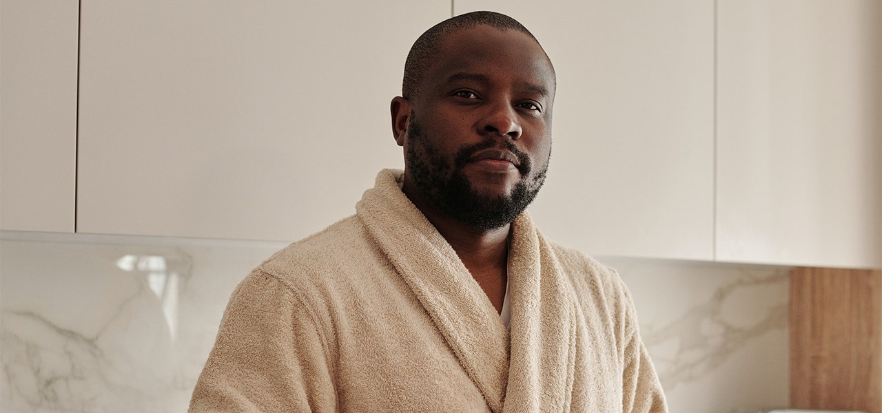 Man standing in his bath robe in his bathroom